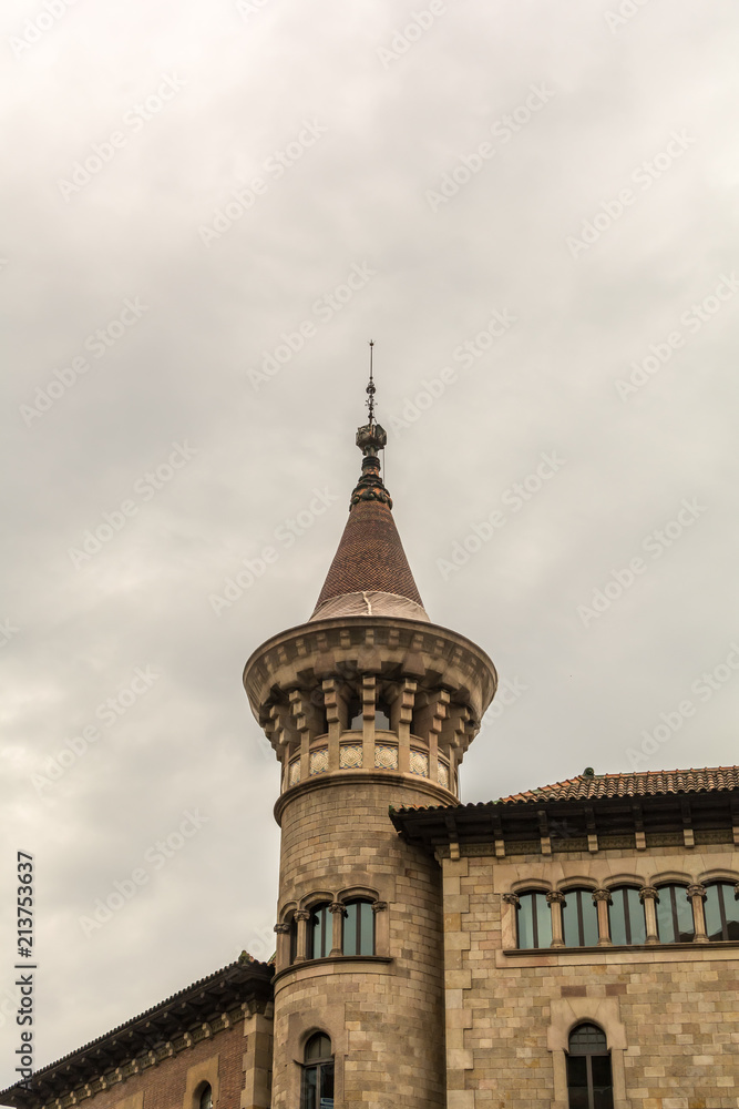 One of two towers of Municipal Conservatory of Barcelona with pointed top reminiscent of the 15th century castles. The brick and stone building was constructed in the years 1916-1927.