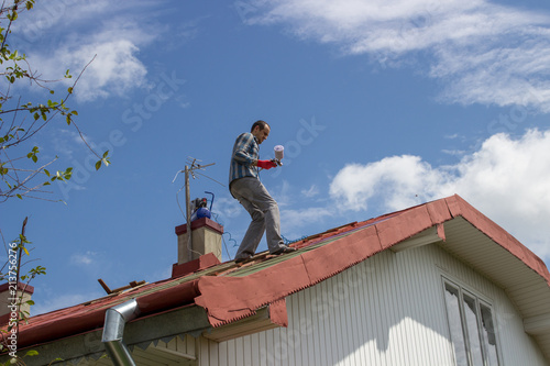 Wallpaper Mural The man stands on the roof to paint Torontodigital.ca