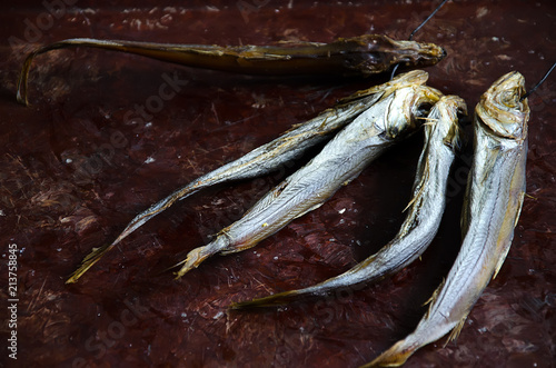 dried, salted fish potasu, on a black leash, which lies on a brown tray