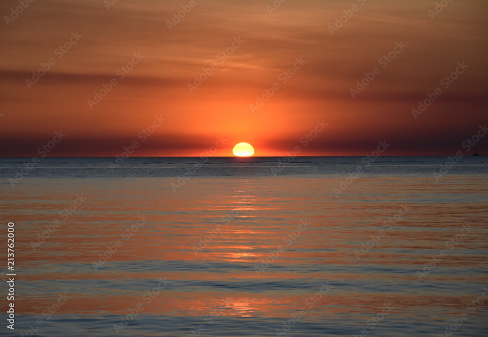 The Sun casts orange shades across an evening sky at Mindil Beach (Darwin, Northern Territory, Australia).
