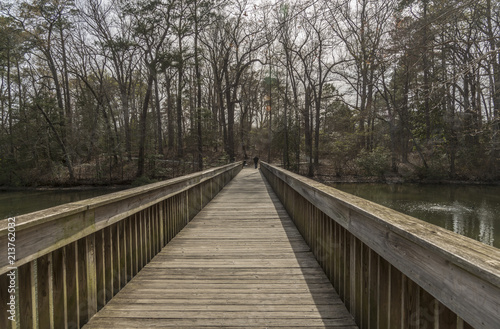Man crossing on a wooden bridge over a river © studiodr