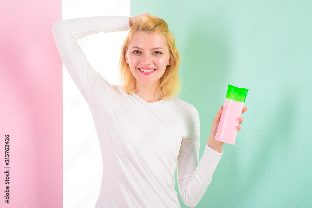 Protect hair before heat styling. Apply protective product first. Hair styling tips. Girl blonde holds shampoo bottle. Woman shows beauty product for hair. Expert tips achieve incredible hair Protect hair before heat styling. Apply protective product first. Hair styling tips. Girl blonde holds shampoo bottle. Woman shows beauty product for hair. Expert tips achieve incredible hair