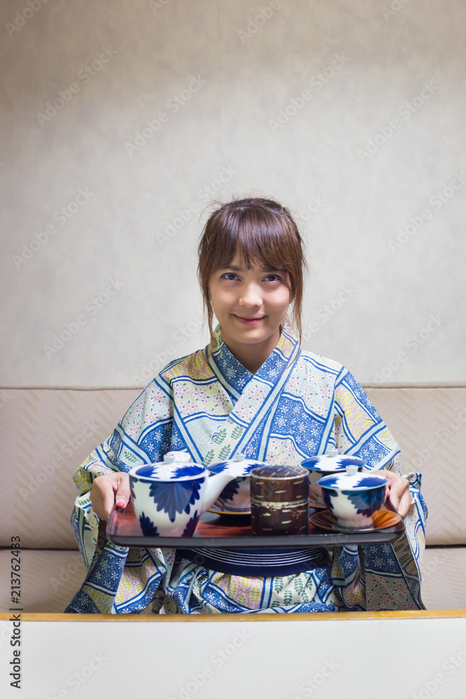Woman wearing traditional japanese yukata or kimono make a tea in japan style. Woman wearing traditional japanese yukata or kimono make a tea in japan style.