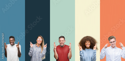Group of people over vintage colors background smiling crossing fingers with hope and eyes closed. Luck and superstitious concept.
