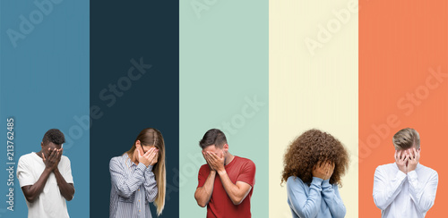 Group of people over vintage colors background with sad expression covering face with hands while crying. Depression concept.