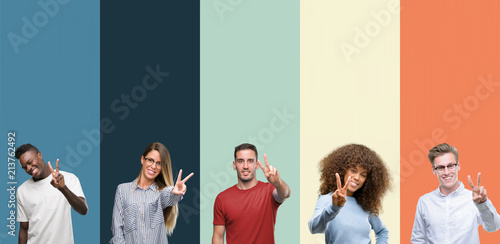 Group of people over vintage colors background smiling looking to the camera showing fingers doing victory sign. Number two.