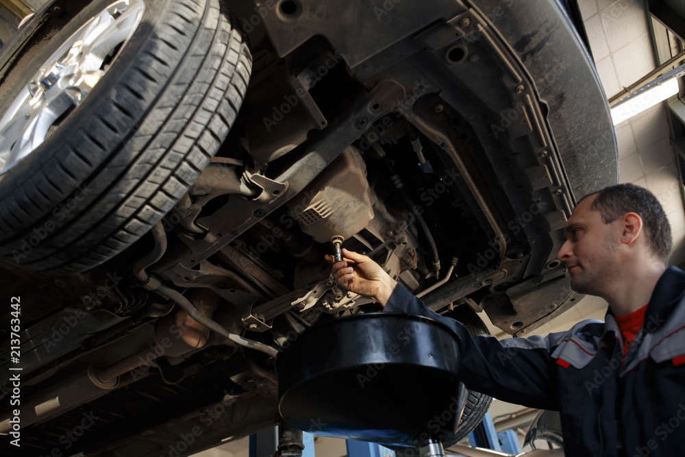 custom made wallpaper toronto digitalProfecional car mechanic changing motor oil in automobile engine at maintenance repair service station in a car workshop.
