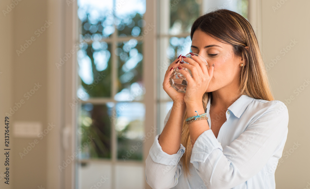 Beautiful young woman drinking a glass of water at home. Lifestyle concept. Beautiful young woman drinking a glass of water at home. Lifestyle concept.