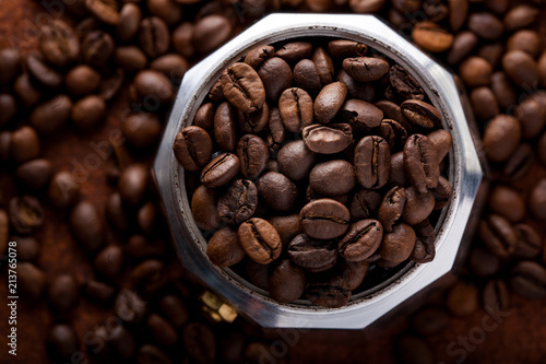 Photo closeup of coffee beans in Aluminium Espresso Coffee Maker. Rusty background. Copy space.