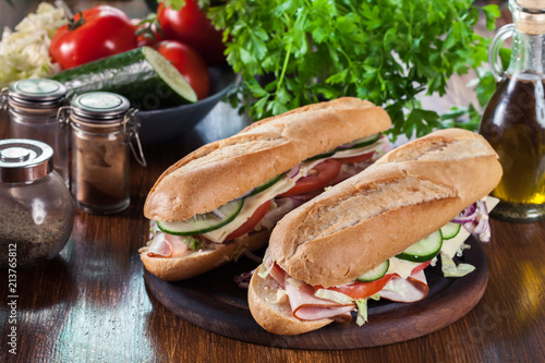 Submarine sandwiches with ham, cheese and vegetables