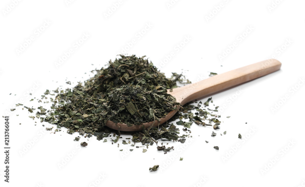 Dry, sliced nettle pile in wooden spoon, isolated on white background Dry, sliced nettle pile in wooden spoon, isolated on white background