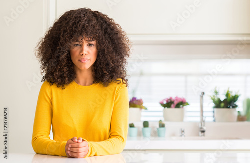 African american woman wearing yellow sweater at kitchen skeptic and nervous, frowning upset because of problem. Negative person.