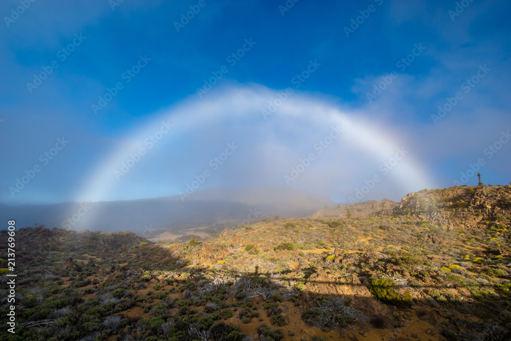 A white rainbow, or a foggy arc after passing a white cloud over the Teide volcano in Tenerife
