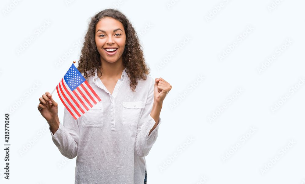 Young hispanic woman holding flag of United Estates of America screaming proud and celebrating victory and success very excited, cheering emotion Young hispanic woman holding flag of United Estates of America screaming proud and celebrating victory and success very excited, cheering emotion
