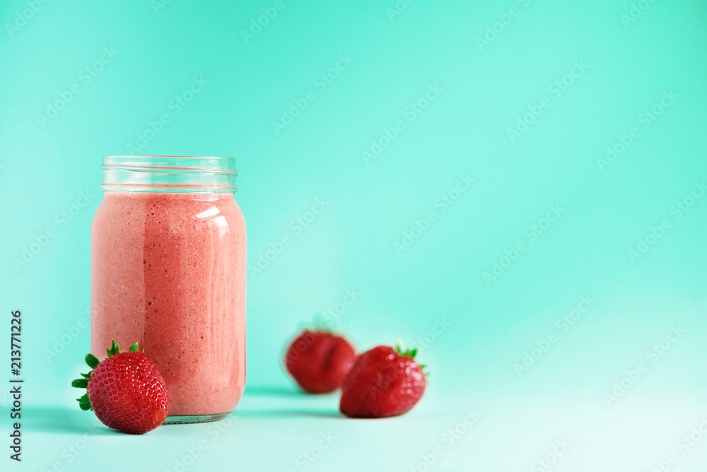 tasty fruit and berries smoothie milkshake in a cute bottle on a blue background with berries around for happy morning tasty fruit and berries smoothie milkshake in a cute bottle on a blue background with berries around for happy morning