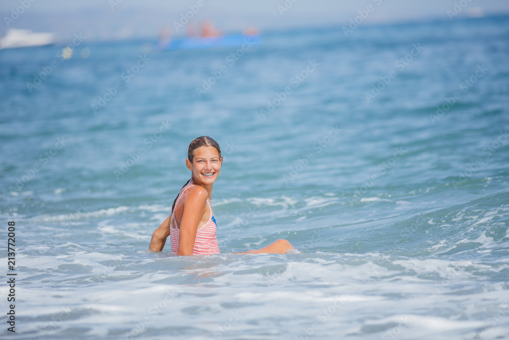 Girl in swimsuit having fun on tropical beach