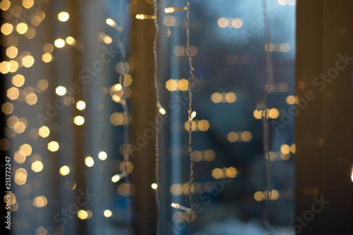 Electric Christmas garland on the window. A little light on the background of lights