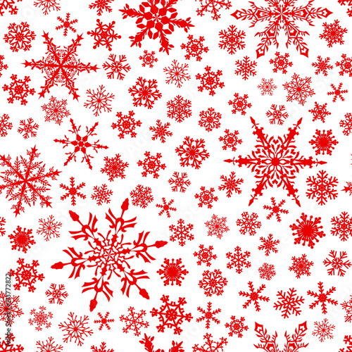 Christmas seamless pattern of snowflakes, red on white background.