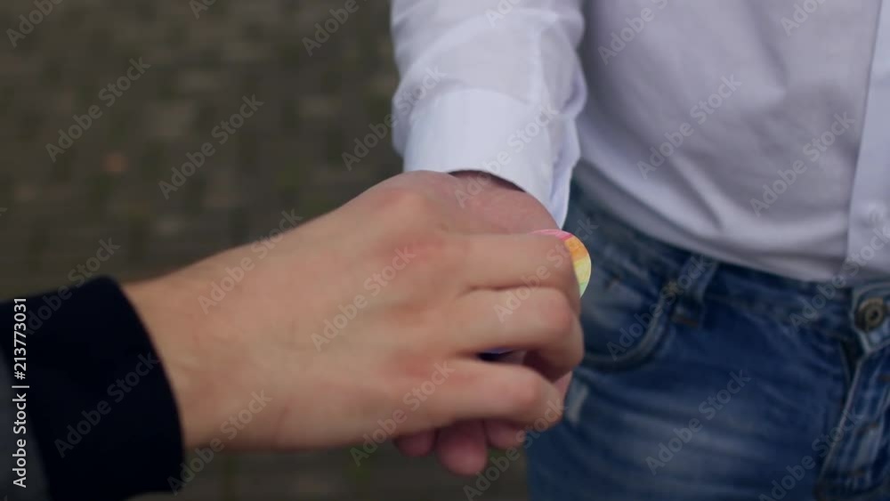 A man holds a heart in the palm of his hand in the form of a flag of LGBT and engagement rings, same-sex marriage, homosexuality, close-ups A man holds a heart in the palm of his hand in the form of a flag of LGBT and engagement rings, same-sex marriage, homosexuality, close-ups