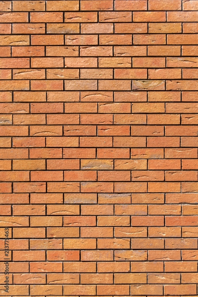 Red brick wall. Decorative brick with artificial defects and cracks. Vertical view Red brick wall. Decorative brick with artificial defects and cracks. Vertical view