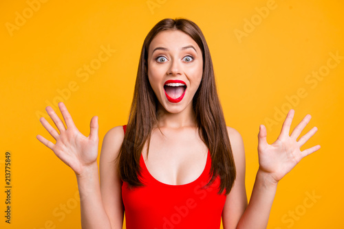 Close up portrait of amazed girl gesturing shock, extremely happy, with wide open eyes and mouth, standing on bright yellow background