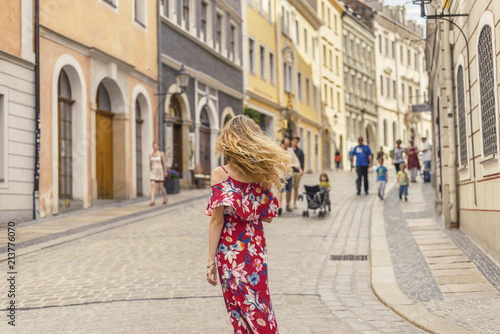 Young woman in red dress taking tour in old german town