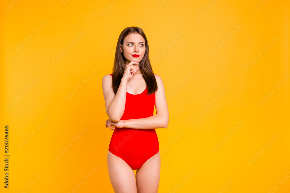 Close up portrait of girl looks thoughtful aside holding her hand and touching her finger to the chin isolated on vivid yellow background Close up portrait of girl looks thoughtful aside holding her hand and touching her finger to the chin isolated on vivid yellow background