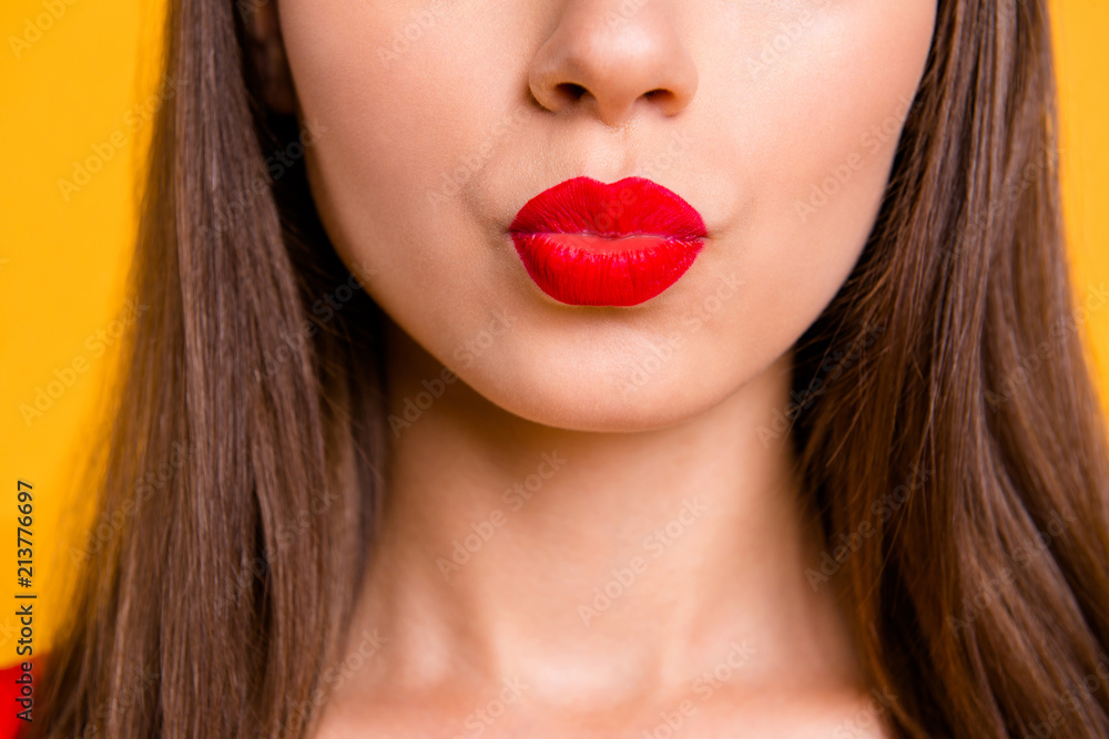 Naklejka premium Bliska portret pół twarzy młodej kobiety z czerwonymi ustami piasku pocałunek na białym tle na jasnożółtym tle