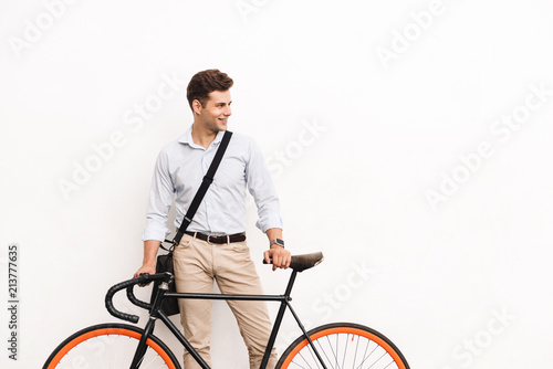 Happy young stylish man dressed in shirt carrying bag