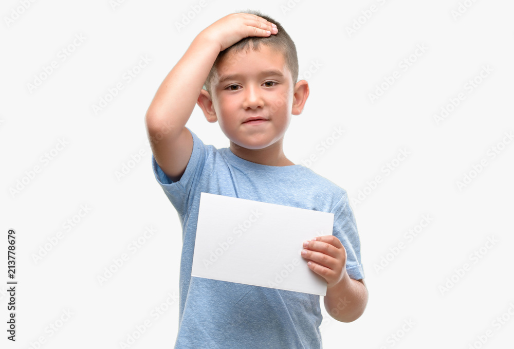 Dark haired little child holding a blank card stressed with hand on head, shocked with shame and surprise face, angry and frustrated. Fear and upset for mistake. Dark haired little child holding a blank card stressed with hand on head, shocked with shame and surprise face, angry and frustrated. Fear and upset for mistake.