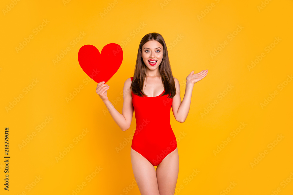 Lovely summer! Portrait of cute brunette woman with big paper carton red heart in hand isolated on yellow vivid background Lovely summer! Portrait of cute brunette woman with big paper carton red heart in hand isolated on yellow vivid background