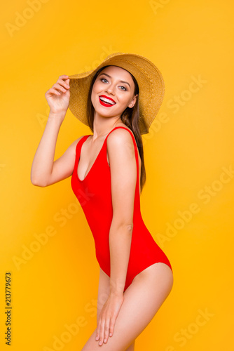 Vertical close up photo portrait of beautiful pretty attractive nice excited cheerful lady touching wide brimmed straw hat isolated on vivid shiny background