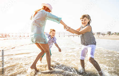 happy mom playing whit her children with the sea 