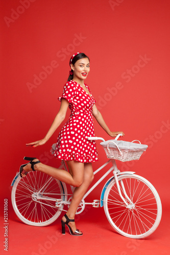 Fototapeta Naklejka Na Ścianę i Meble -  beautiful girl in pin-up style with a Bicycle