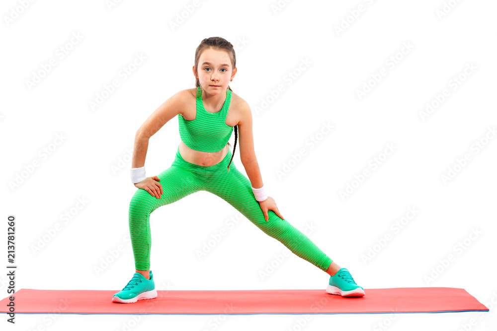 Kid girl doing fitness or yoga exercises isolated on white background. Sport concept. Kid girl doing fitness or yoga exercises isolated on white background. Sport concept.