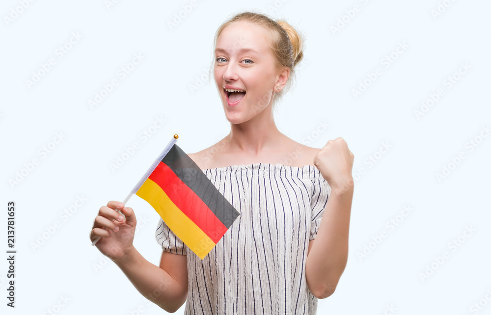 Blonde teenager woman holding flag of Germany screaming proud and celebrating victory and success very excited, cheering emotion Blonde teenager woman holding flag of Germany screaming proud and celebrating victory and success very excited, cheering emotion