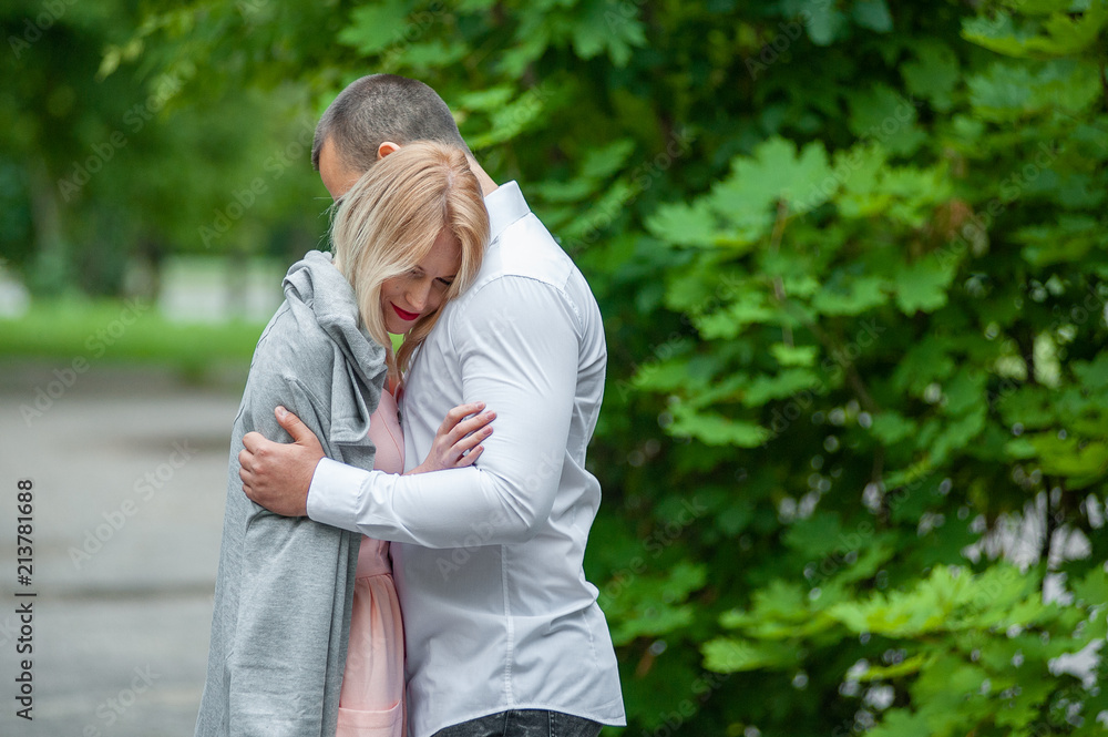 Fototapeta premium Happy young beautiful caucasian couple hugging. Happy romantic couple in love and having fun with daisy at the park outdoor in summer day, beauty of nature, harmony concept