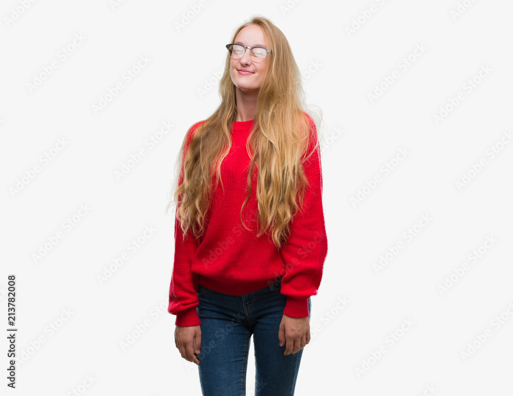 Blonde teenager woman wearing red sweater winking looking at the camera with sexy expression, cheerful and happy face. Blonde teenager woman wearing red sweater winking looking at the camera with sexy expression, cheerful and happy face.