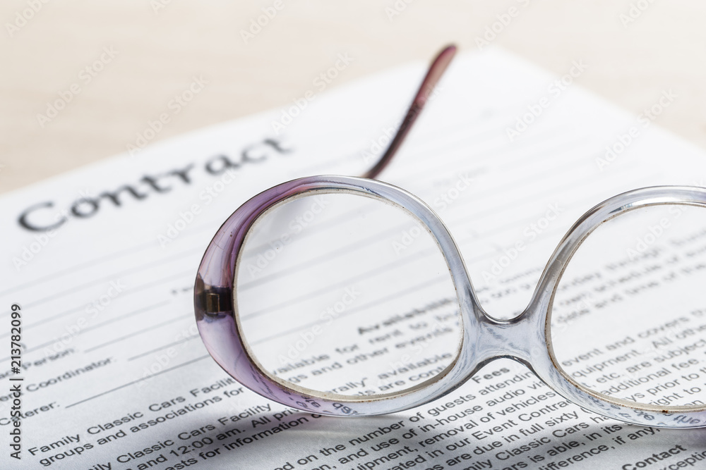 Close up shot of Eyeglasses on contract document papers business concept Close up shot of Eyeglasses on contract document papers business concept