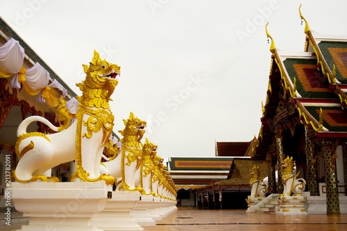 Statue of the Lion in Buddhism. / The Statue of the Lion in Wat Phra That Choeng  Chum. Sakon Nakhon Province Thailand ,Have white sky in the background photo