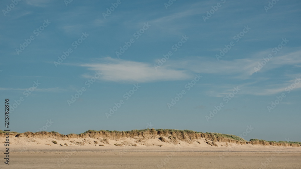 Fototapeta premium England, Cornwall, Daymer Bay, Sand dunes and blue with whisky cloudsky