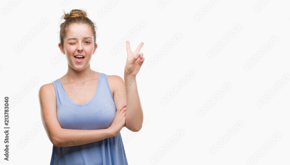 Young blonde woman smiling with happy face winking at the camera doing victory sign. Number two. Young blonde woman smiling with happy face winking at the camera doing victory sign. Number two.