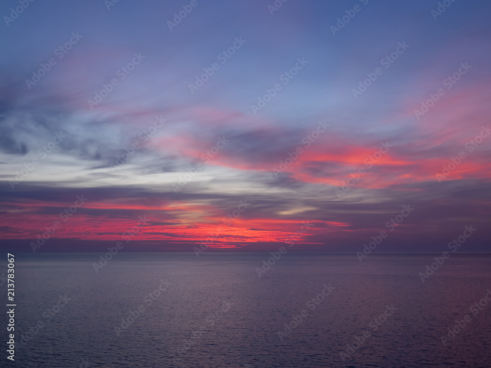 Red and purple sky above sea