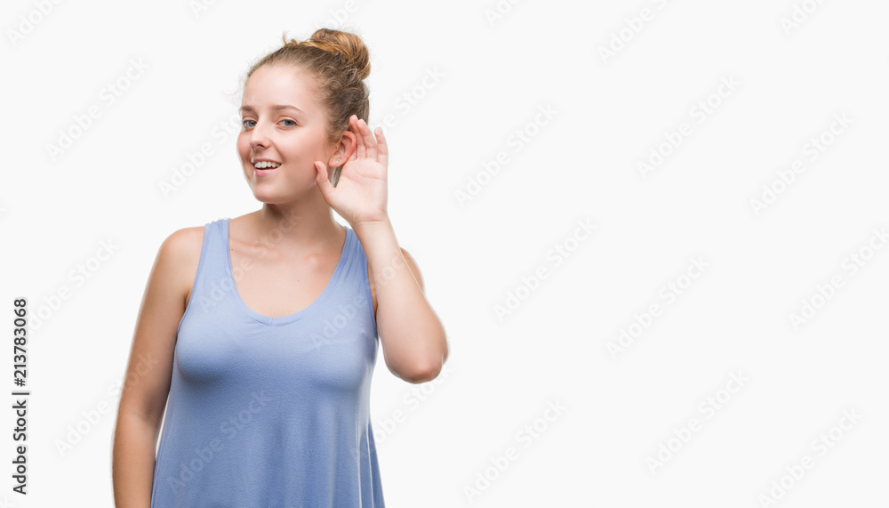 Young blonde woman smiling with hand over ear listening an hearing to rumor or gossip. Deafness concept. Young blonde woman smiling with hand over ear listening an hearing to rumor or gossip. Deafness concept.