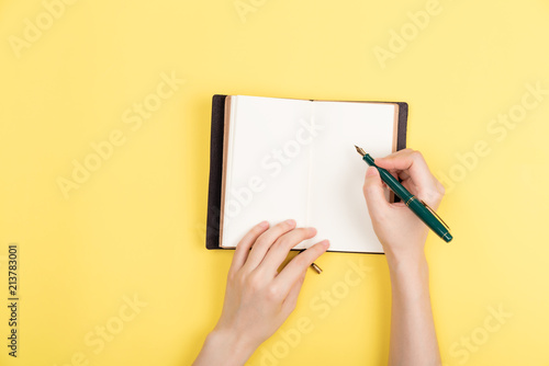 girl's hand writing in notepad.