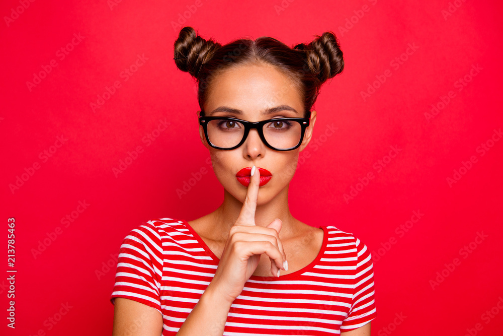 Shh! Portrait of attractive mysterious girl in glasses gesturing silence sign with forefinger red pout lips looking at camera isolated on red background - obrazy, fototapety, plakaty 