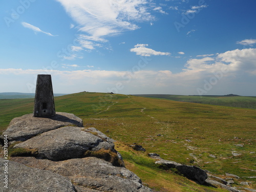 Triangulation pillar on Yes Tor looking to High Willhays with white clouds in a blue sky, Dartmoor National Park, Devon, UK photo