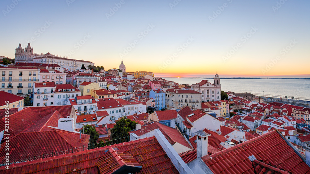 A view of Lisbon's rooftops at sunrise from the Miradouro das Portas do Sol - Lisbon, Portugal 