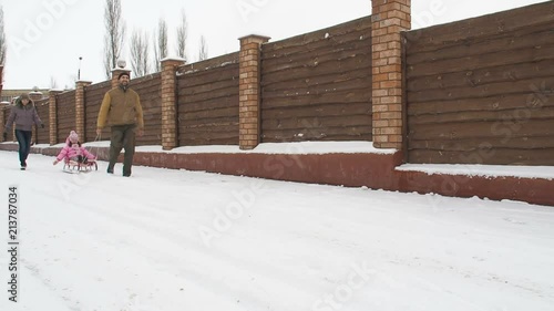 Wallpaper Mural Happy family in the snow. Parents roll the child on a sled. Torontodigital.ca