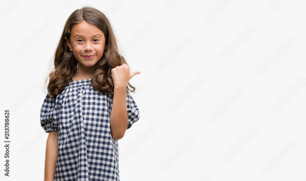 Brunette hispanic girl wearing black and white dress pointing and showing with thumb up to the side with happy face smiling Brunette hispanic girl wearing black and white dress pointing and showing with thumb up to the side with happy face smiling
